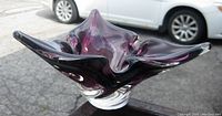 Side view of the plum colored abstract Murano art glass bowl showing organic star-shaped form and thick clear glass base.