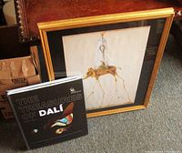 Photo shows the framed Salvador Dali Elephant On Stilts print and the art book The Treasures of Dali on carpeted floor.