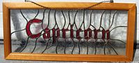 Front view of wood framed stained glass panel featuring Capricorn lettering.