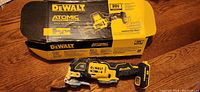 Photo of Dewalt branded box and the multitool placed on wooden surface.
