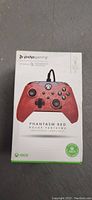 Front view of sealed PDP Gaming wired Xbox controller box showing red controller image and branding.
