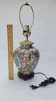 Full view of Chinese porcelain lamp next to a ruler showing approximate height, with attached electrical plug and cord visible.