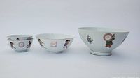 Four Chinese porcelain bowls arranged with one large and three smaller bowls, showing hand-painted children playing sports decoration