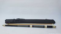 Full view of pool cue disassembled showing cue sections and black carrying case