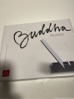 Top of the Buddha Board box with the Buddha Board logo and white pen on display.