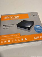 Clickfree 1TB external hard drive retail boxed packaging showing branding, capacity, and function as automatic home backup drive.