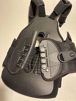 Full view of black DonJoy back support brace showing adjustable tension system and straps.