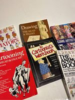 A set of drawing and animation books, including titles on cartooning, head and figure drawing, cartoonist workbooks, comic artists from Asia, and a guide to animation films.