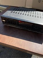 Top and front angled view showing the Fisher stereo receiver with vented top and power rating label.