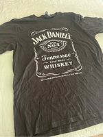 Black Jack Daniels T-shirt laid flat showing front logo print.