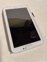 Front view of Samsung Galaxy Tab 3 T210 tablet with screen off showing front camera and Samsung logo.