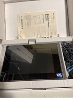 Sony Digital Photo Frame DPF-V900 in box with power cable and manual visible.