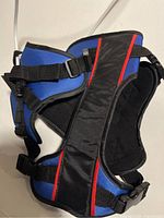 Blue and black pet support harness with red trim, showing adjustable straps and buckles for fitting.