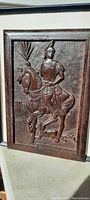 Full view photo of the 12" x 10" carved wooden artwork showing the soldier in armor on horseback with carved lettering on the lower right.