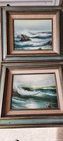 Both vintage ocean scene oil paintings displayed together, showing frames and artwork detail.
