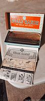 Antique Rolls Razor in original box with paperwork shown, including the chrome razor and boxed lid with branding visible.