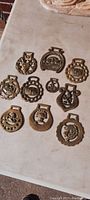 Full lot of 10 brass buckles laid out showing all individual buckle designs and sizes.
