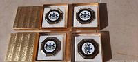 Four vintage Pennsylvania State Coat of Arms badges in their original period boxes, gold patterned exterior with white cushioned interior.