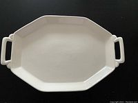 Top-down view of octagonal off white platter showing handles and smooth surface.