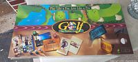 Top view of sealed Monopoly Golf board game box with colorful golf course illustrations and text.
