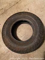 Top view of the used black tire showing overall shape and tread pattern.