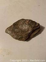 Front view of mica schist rock showing its uneven shape and shiny flakes.