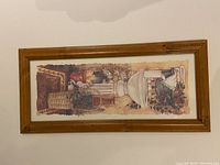 Photo of framed picture featuring a white urn with flowers, basket, and textured background in natural wood frame.