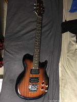 Full front view of guitar body and neck on grey surface.