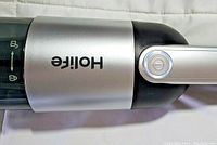 Close-up photo of Holife handheld vacuum cleaner showing logo and power button.