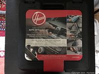 Closed black hard plastic storage case with Hoover label showing kit overview and branding.
