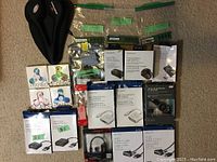 Full view of the milk crate contents showing bicycle seats, multiple fidget spinners, electronic adapters and cables in packaging, and computer RAM memory.