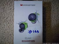 Front of original product box showing Monster branding, iSport Champion model, and image of earbuds with water splash indicating waterproof feature