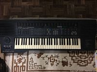 Top-down view of the full keyboard showcasing the 61 keys, speaker grills on the left, and labeled function buttons across the control panel.