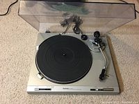 Full view of Technics SL-B202 turntable with clear dust cover on beige carpet.