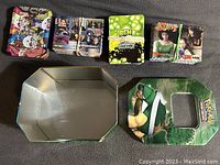 Photo of four trading card sets and Pokémon tin box laid out: Pokémon Black & White Dragons Exalted tin, The 4400 Season 2 cards bundled, Ben 10 collectible cards box, The Complete Babylon 5 cards, and empty Pokémon tin box and lid