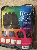 Original packaging of FH Group universal fit black flat cloth car seat covers showing product features and images.