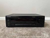 Front view of Pioneer VSX-452 receiver showing digital display, control knobs and buttons.