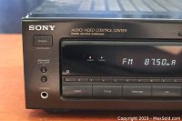 Front left close-up showing power button, speaker on/off toggle, headphones jack, and digital delayed surround branding with display showing FM 87.50