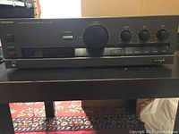 Front view of the Technics SU-G50 amplifier showing volume knob, input selector buttons, and other control knobs.