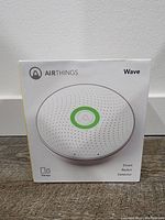 Airthings Wave radon detector in its sealed retail packaging showing front of box with product image and branding.