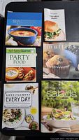 Top view of 5 of the cook books showing covers with food photography including salads, muffins, party food, and lemons theme.