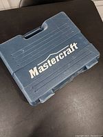 Closed Mastercraft blue hard plastic carrying case with logo on top.