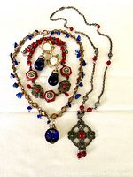 Full set of three vintage necklaces and three pairs of bold costume earrings arranged on white surface