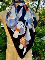 Scarf displayed on mannequin showing overall design and colors, focusing on mushroom pattern and style.