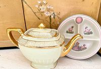 Hall teapot and Bartsch warming baby dish shown side by side, highlighting gold trim and deer illustrations