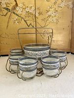 Full view of the cocktail set including metal caddy, ice bucket, and six tumblers arranged around the caddy.