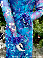 Close-up of the cuff and sleeve details showing the blue floral chiffon fabric, sheer quality of the sleeves, and ruffled embellished cuffs with gathered fabric accents.