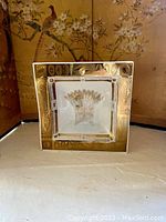 Deep square decorative dish with gold wheat motif and patterned gold border on table surface