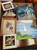 Photo showing entire lot with all paintings and string art visible on wooden surface