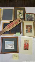 Overview of lot items including Board of Education paddle, two vintage school slates, four framed prints and illustrations arranged on a table.